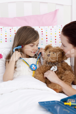 Mother and daughter playing doctors in bed