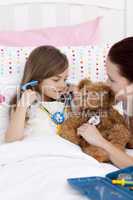 Mother and daughter playing doctors in bed