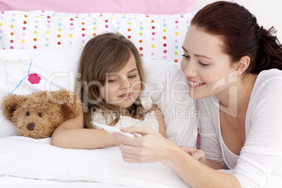 Mother taking her daughter's temperature