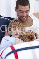 Portrait of father and son reading a book in bed