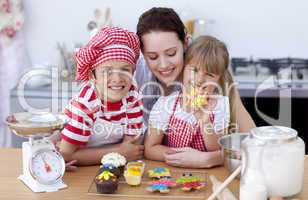 Smiling mother and children baking in the kitchen