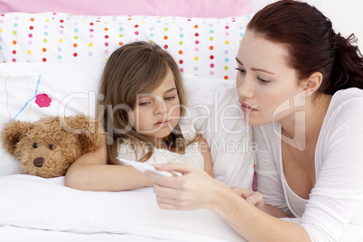 Mother taking sick daughter's temperature