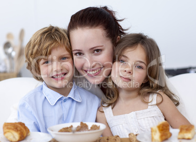Children having breakfast with their mother