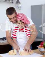 Man and little boy cutting bread