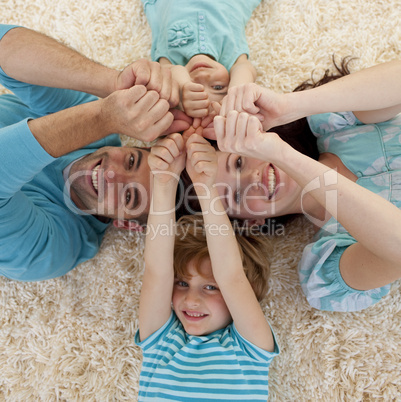 High angle of family on floor with heads and hands together
