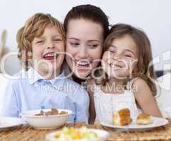 Children having breakfast with their mother
