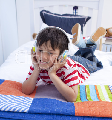 Boy relaxing in bed listening to music