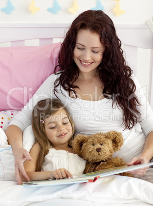 Mother and daughter reading in bed