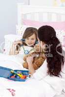Woman and little girl playing with a stethoscope