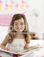 Little girl reading in bed