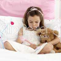 Little girl writing in bed