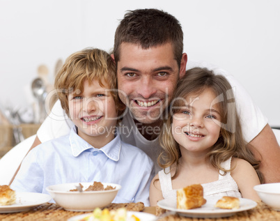 Children having breakfast with their father