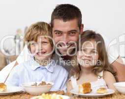 Children having breakfast with their father