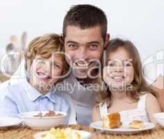 Portrait of children having breakfast with their father