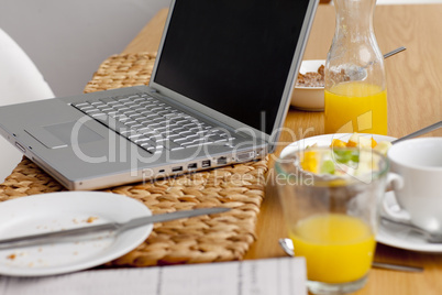 Laptop on a kitchen table. Working having breakfast