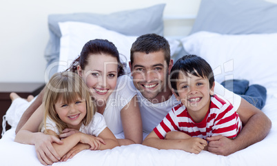 Family lying in bed together