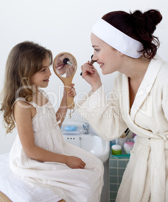 Daughter helping her mother in makeup