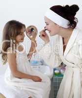 Daughter helping her mother in makeup