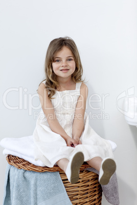 Little girl sitting in bathroom