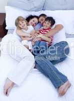 High view of parents and children relaxing in bed