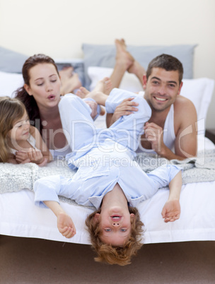 Parents and children having fun in bed