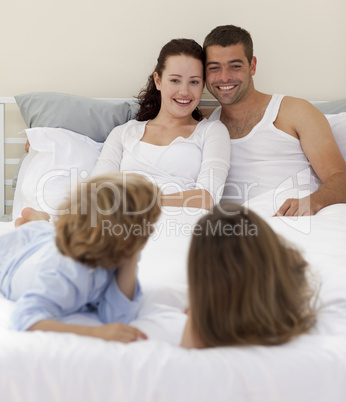 Brothers and parents lying in bed