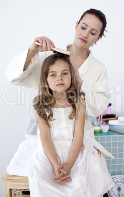 Mother brushing her daughter's hair
