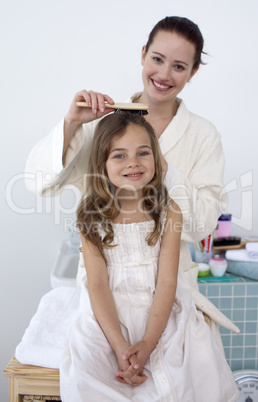 Mother doing her daughter's hair