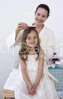 Mother doing her daughter's hair