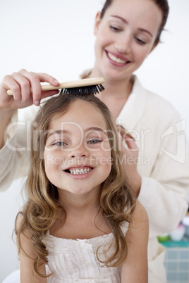 Portrait of mother doing her daughter's hair
