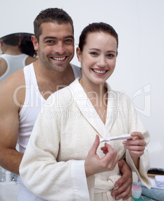 Happy couple looking at a positive pregnancy test