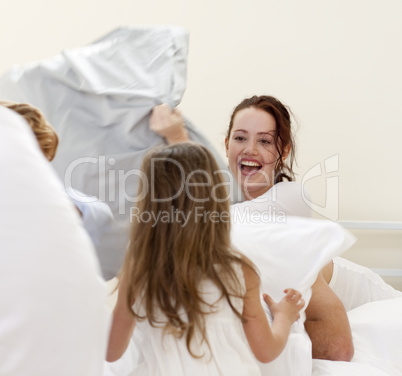 Mother and children having a pillow fight