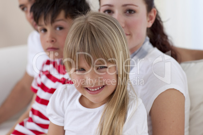 Little girl sitting on sofa with her family