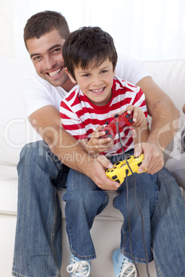 Smiling father and kid playing video games at home