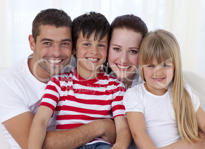 Portrait of smiling family sitting on sofa together