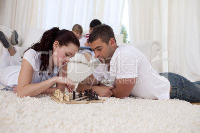 Couple playing chess on floor in living-room