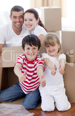 Family moving house with boxes and thumbs up
