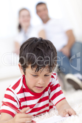 Smiling kid drawing on floor in living-room