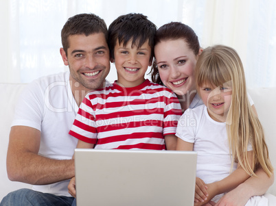 Portrait of family at home using a laptop