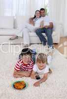 Happy children watching television on floor in living-room
