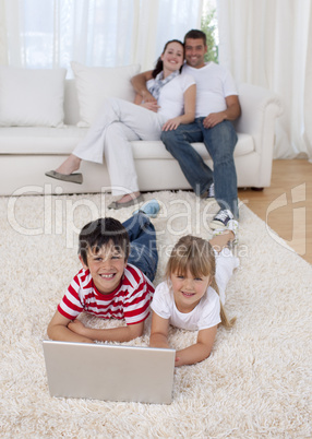 Children using a laptop on floor in living-room