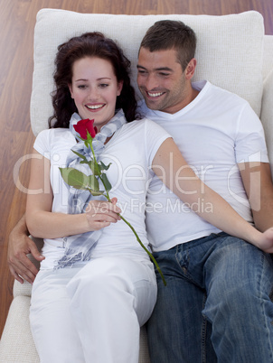 Lovers on sofa with a rose