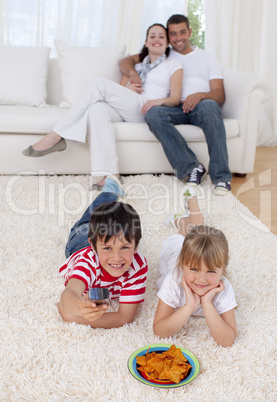 Brother and sister watching television on floor in living-room