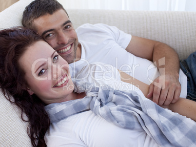 Smiling couple lying on sofa