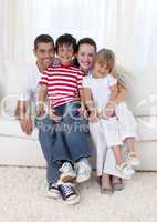 Smiling family sitting on sofa together