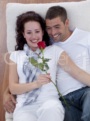 High angle of lovers on sofa with a rose