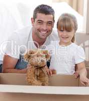 Father and daughter with a teddy bear moving home