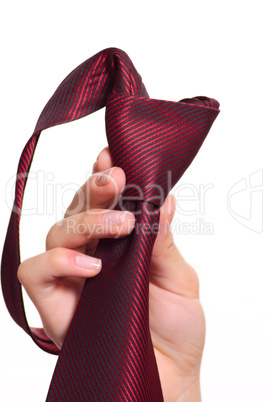 Female hand holding a red striped tie with the fastened knot