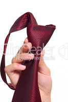 Female hand holding a red striped tie with the fastened knot