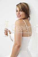 schöne junge Frau in einem Brautkleid mit einem Glas Champagner